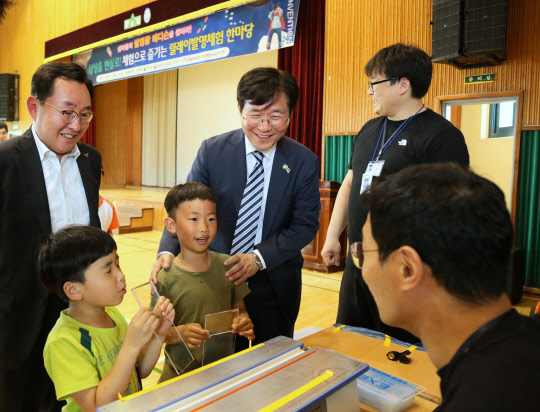 성윤모 특허청장(왼쪽 두번째)이 5일 오전 전남 신안군 임자도에 위치한 임자중학교에서 열린 '2018 창의·도전 릴레이 발명체험 한마당'에 마련된 '릴레이 창의융합 부스'에서 발명학생으로부터 발명품에 대한 설명을 듣고 있다.  특허청 제공